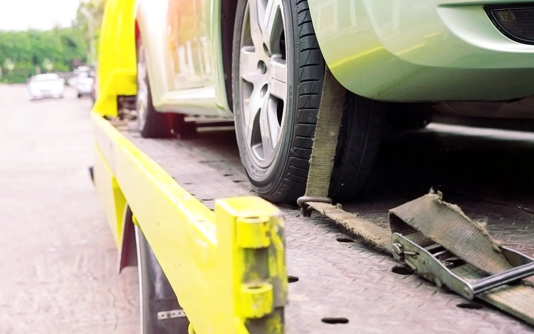 Van recovery specialist loading vehicle onto recovery truck in challenging conditions